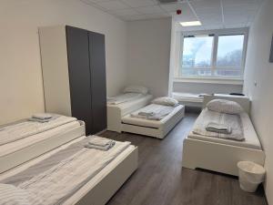 ein Zimmer mit drei Betten und einem Fenster in der Unterkunft DRIVER ROOMS in Nürnberg