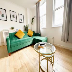 a living room with a green couch and a glass table at Serene Ocean Side Apartment BTN in Brighton & Hove