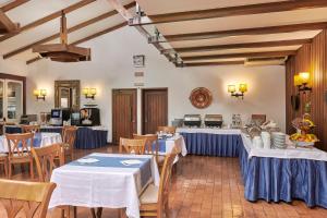 a restaurant with tables and chairs with blue tablecloths at Hotel Apartamento Do Golfe in Vilamoura