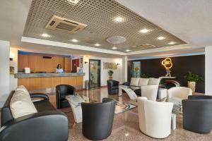 a lobby with black and white chairs and a counter at Hotel Apartamento Do Golfe in Vilamoura +43 photos