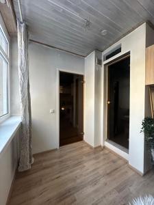 an empty living room with wood floors and a ceiling at Apartment with sauna and fireplace in Viitna