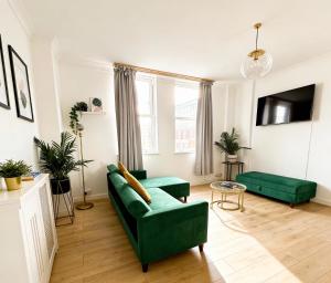 a living room with a green couch and a tv at Serene Ocean Side Apartment BTN in Brighton & Hove