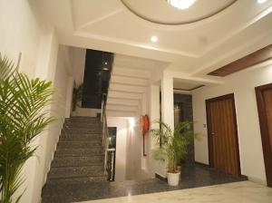 a hallway with stairs and potted plants in a building at Hotel Global Inn Gold in Lucknow