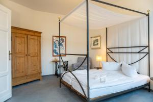 a bedroom with a four poster bed with white sheets at Villa Cremona in Bansin