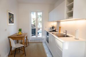 a kitchen with white cabinets and a wooden table at Villa Cremona in Bansin