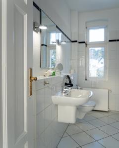 a white bathroom with a sink and a toilet at Villa Cremona in Bansin +53 photos