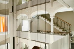 a reflection of a staircase in a glass wall at Suite Apartments by Hotel Gabbani in Lugano
