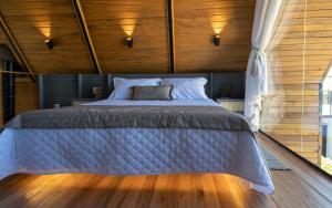 a bedroom with a large bed with wooden walls at Cabanas Horizonte Cambará Nature in Cambará