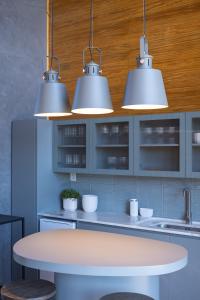 a kitchen with three lights above a table at Cabanas Horizonte Cambará Nature in Cambará