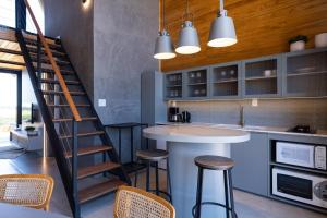 a kitchen with a staircase and a counter with stools at Cabanas Horizonte Cambará Nature in Cambará +18 photos