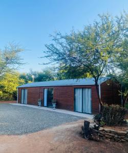 a red brick house with a tree in front of it at Desert Bloom Cottage in Buffelskloof