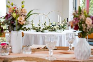 a table with vases of flowers on top of it at Landhotel Kirchberg - Hotel Garni in Kirchberg an der Jagst