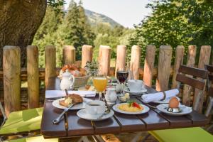 a wooden table with breakfast foods and drinks on it at Hotel Bad Rain mit Oberstaufen PlusGolf in Oberstaufen