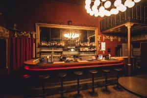 a bar in a pub with a bunch of stools at Ballhaus Berlin Hostel in Berlin +37 photos