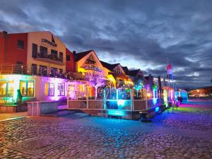 a group of buildings with colorful lights on a street at Pension Hafenblick in Barth