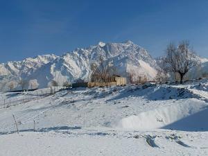 a snow covered hill with a mountain in the background at The Crescent Resort in Skardu +21 photos