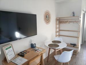 a living room with a tv and a table and chairs at Le 16 Place de l'Abbatiale in Évron