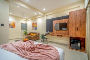 a bedroom with a bed and a tv and a couch at Benchmark Residences in Indore