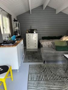 a living room with a bed and a couch at Mysig stuga med wifi in Bergshamra