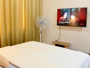 a hospital room with a bed and a flat screen tv at Hannah’s Morning Sun - Studio Room in Manila