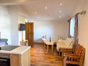 a kitchen and living room with a couch and a table at Apartment Daniel by Interhome in Hollersbach im Pinzgau +48 photos
