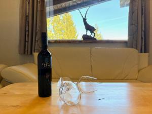 a bottle of wine and a pair of glasses on a table at Apartment Daniel by Interhome in Hollersbach im Pinzgau