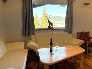 a living room with a bottle of wine and a table at Apartment Daniel by Interhome in Hollersbach im Pinzgau
