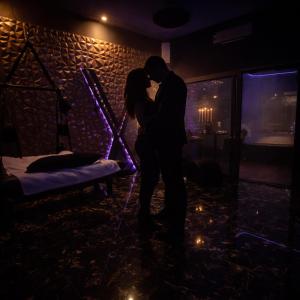 a man and a woman kissing in a room at love room mes petits secrets miniac morvan avec jacuzzi privatif in Miniac-Morvan +16 photos
