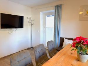 a dining room with a table and chairs and a television at Apartment Benjamin by Interhome in Hollersbach im Pinzgau