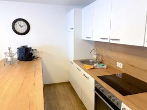 a kitchen with a sink and a clock on the wall at Apartment Benjamin by Interhome in Hollersbach im Pinzgau