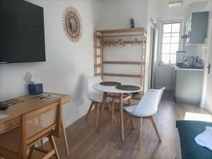 a room with a table and chairs and a kitchen at Le 16 Place de l'Abbatiale in Évron