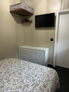 a bedroom with a bed and a tv on the wall at Quiet Place in Machico