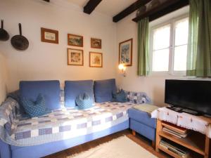 a living room with a blue couch and a tv at Chalet Hüttl by Interhome in Trins