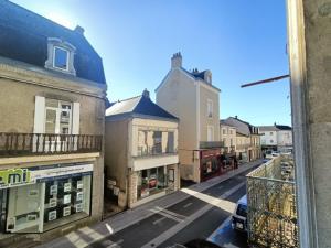 a view from a window of a street with buildings at Le 16 Place de l'Abbatiale in Évron