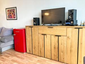 a living room with a tv on a wooden entertainment center at Apartment Ostsee-Residenz - DMP173 by Interhome in Damp