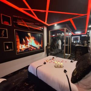a room with a fireplace and a bed with candles at love room mes petits secrets miniac morvan avec jacuzzi privatif in Miniac-Morvan