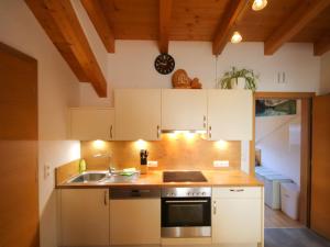 a kitchen with white cabinets and a sink at Holiday Home Bergblick by Interhome in Kappl
