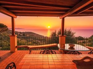 a patio with a view of the ocean at sunset at Villa Ricali by Interhome in Porto Santo Stefano