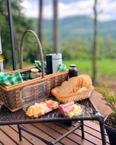 a picnic basket with food and bread on a table at Pousada Jardim Encantado - Suítes em Container na cidade do Cristo Protetor - Encantado RS in Encantado