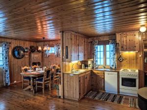 a kitchen with wooden cabinetry and a table with chairs at Holiday Home Midtholmen by Interhome in Konsmo