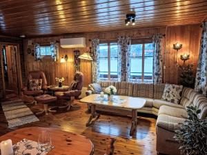 a living room with a couch and a table at Holiday Home Midtholmen by Interhome in Konsmo +37 photos