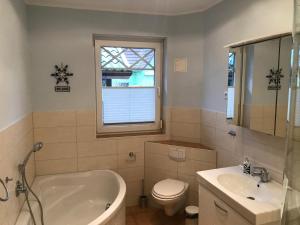 a bathroom with a tub and a toilet and a sink at Sonnendeck in Prerow +12 photos