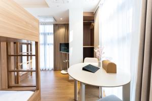 a small room with a white table and a bed at akastay Myeongdong in Seoul