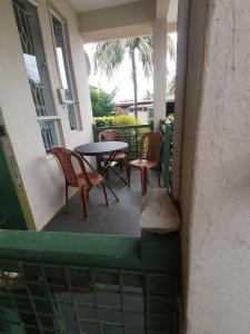 a patio with chairs and a table on a porch at Au Calme in Baie du Tombeau