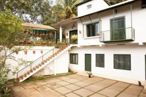 a white building with stairs and a balcony at House StoneHaven in Kaniyāmbetta
