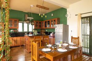 a kitchen with a wooden table and a refrigerator at House StoneHaven in Kaniyāmbetta