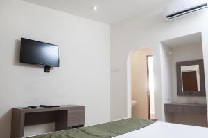 um quarto com uma televisão de ecrã plano na parede em Hotel La Riviera em Culiacán