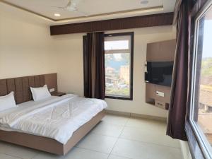 a bedroom with a bed and a large window at City Palace Sagar in Sāgar
