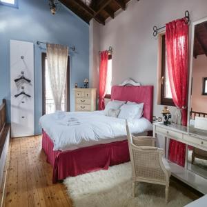 a bedroom with a large bed with red curtains at Amadrias Villa Florina in Florina