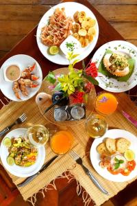 a wooden table with plates of food on it at Ecolodge Nosy Faly in Nosy Be